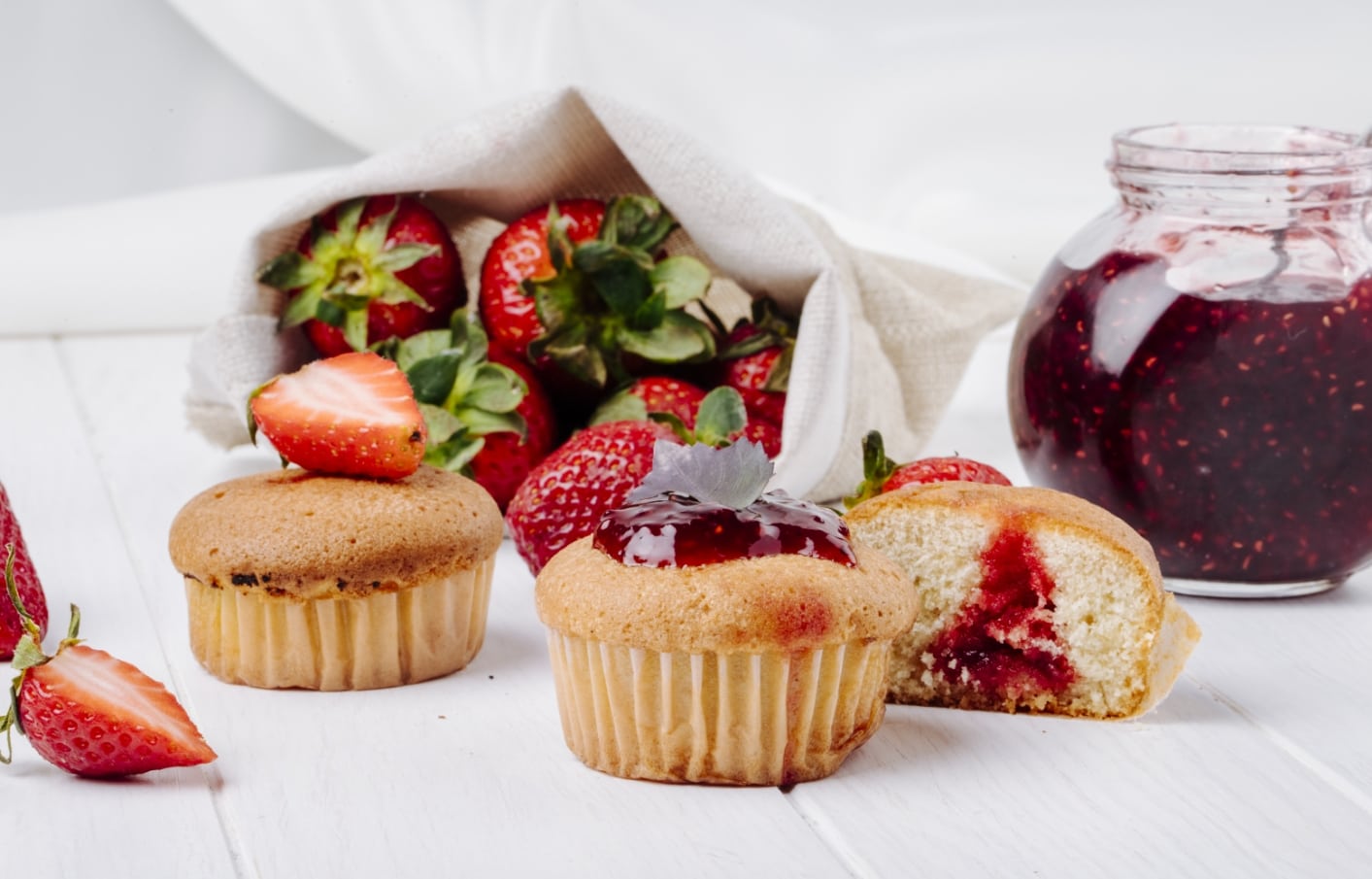 vista-lateral-cupcakes-mermelada-fresa-albahaca-fresa-fresca-sobre-fondo-blanco